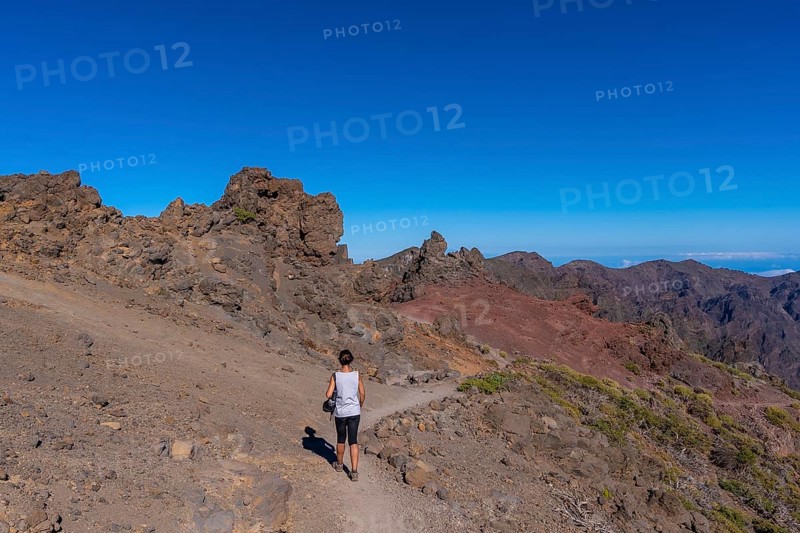 A young woman walking atop the Caldera de Taburiente volcano near Roque de los Muchachos one summer afternoon