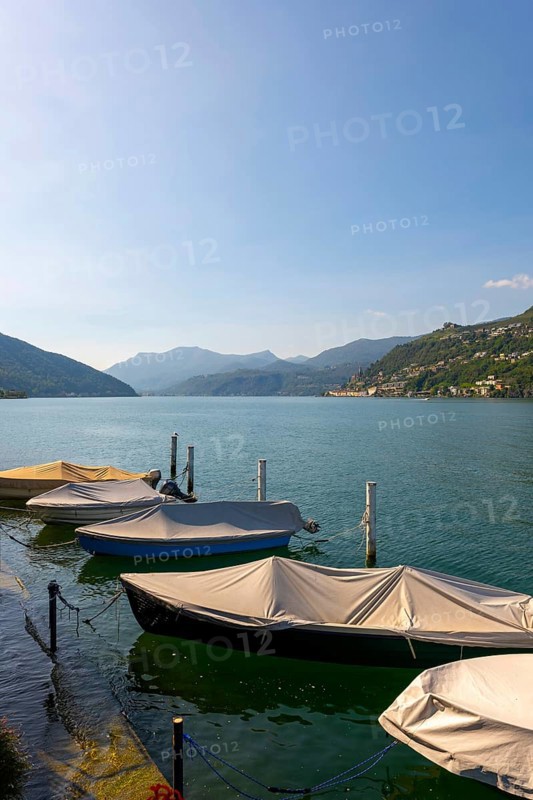 Port with Boats in Brusino Arsizio on the Waterfront in a Sunny Summer Day on Lake Lugano and Mountain View over Morcote