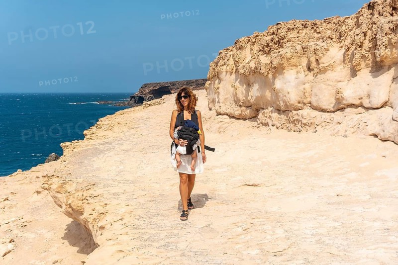 A young mother with her son walking on the path in the Cuevas de Ajuy