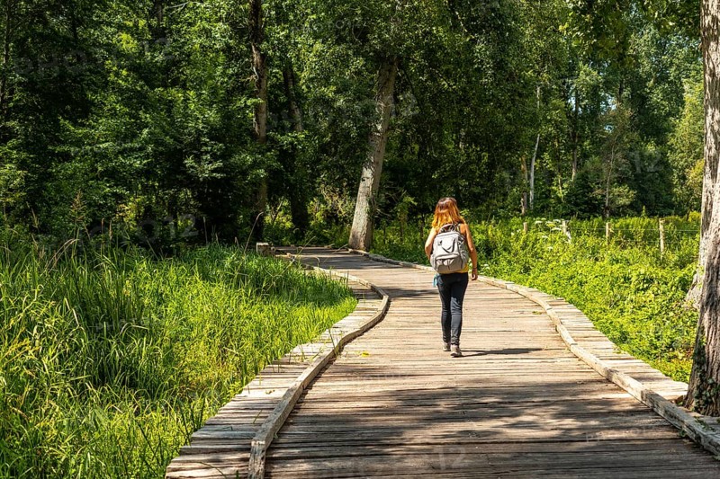 A young woman on the footpath along a footbridge between La Garette and Coulon