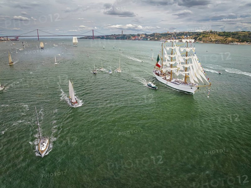 Aerial drone view of tall ships with sails sailing in Tagus river towards the Atlantic ocean in Lisbon