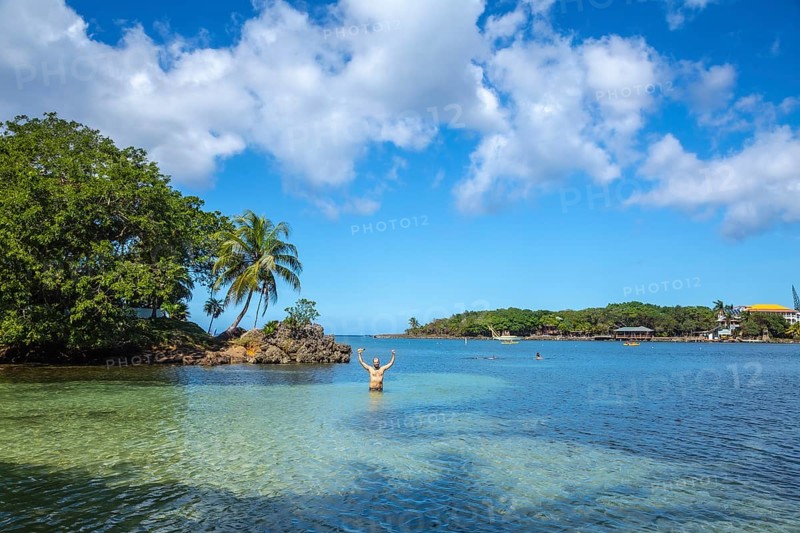 A young man entering the Caribbean Sea at West End Beach on Roatan Island. Honduras