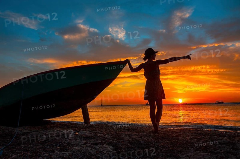A young woman in a boat at Roatan Sunset from West End. Honduras