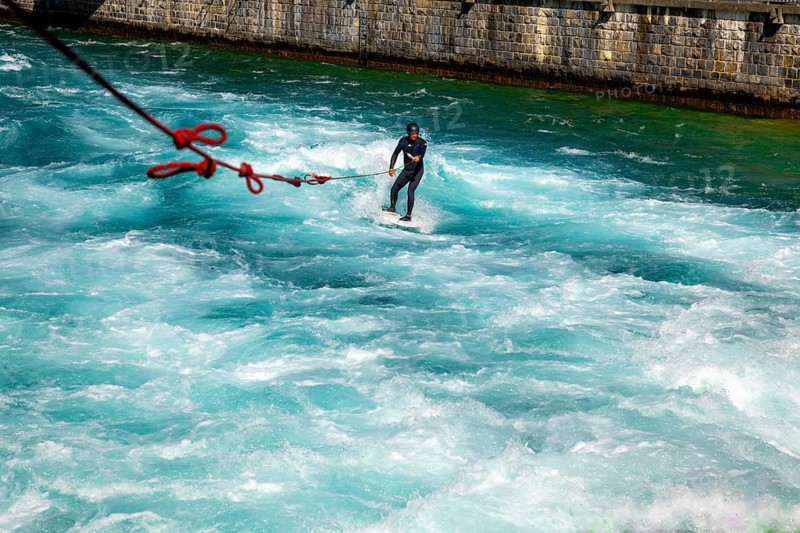 Surfer Surfing on River Aare in City of Thun in a Sunny Summer Day in Bernese Oberland