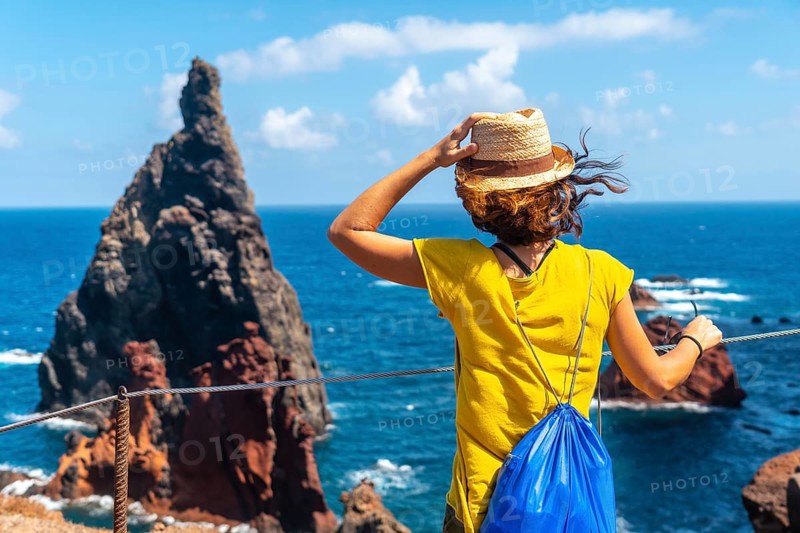 A young woman in the viewpoint looking at the rock formations at Ponta de Sao Lourenco