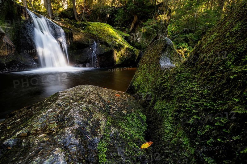 Waterfall in autumn forest with rocks