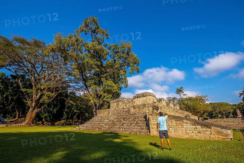 A young man looking at a pyramid in the temples of Copan Ruinas. Honduras