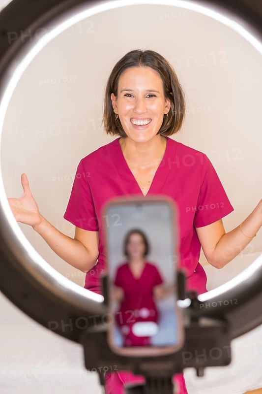 Vertical photo of a female doctor nutritionist recording a video blog with the mobile