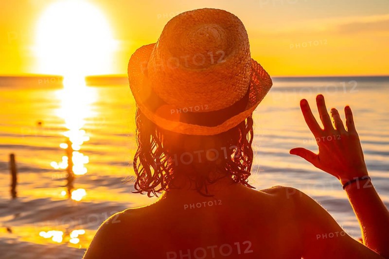 A young girl with a hat on a sunset in Roatan. Honduras
