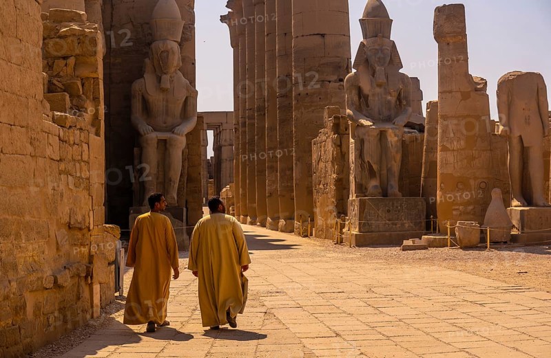 Two local men visiting the Egyptian Temple of Luxor and its precious column