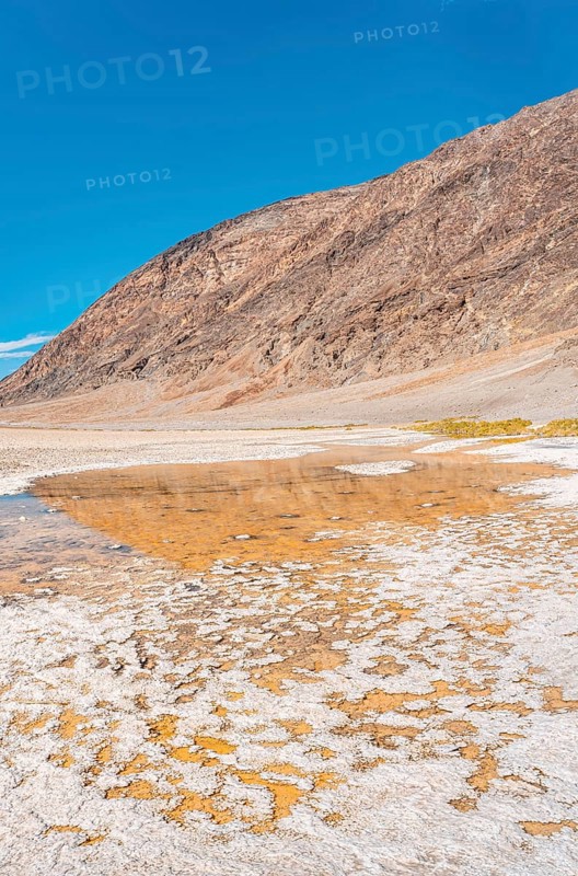 Vertical panoramic of the water in the immense white salt flat of Badwater Basin