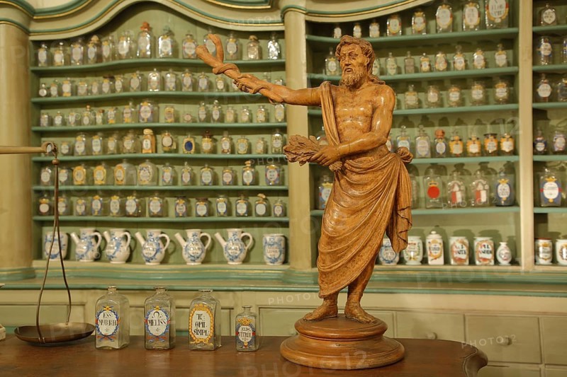 Interior view with sculpture and rows of bottles sorted in the shelf