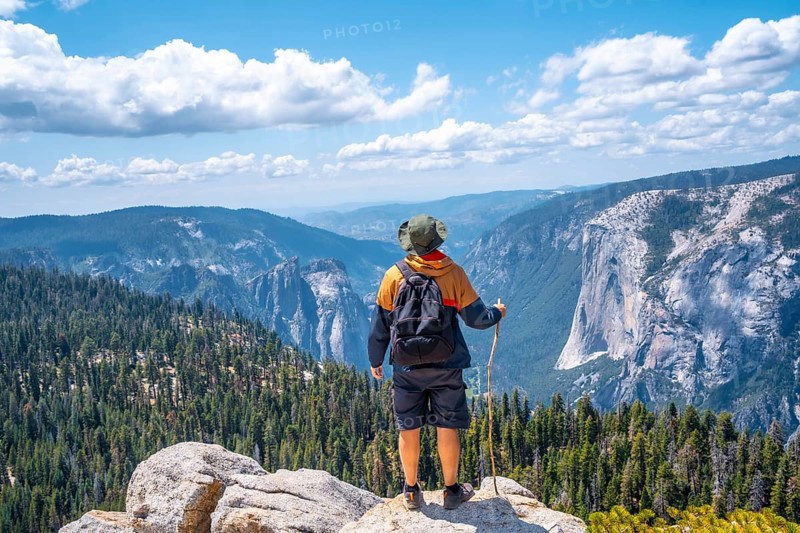 A young man with a stick for walking in Sentinel Dome in Yosemite National Park. United States