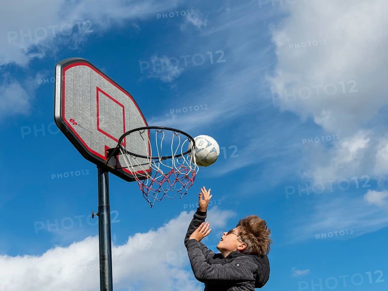 Basketball jumping with the ball to the basket and net