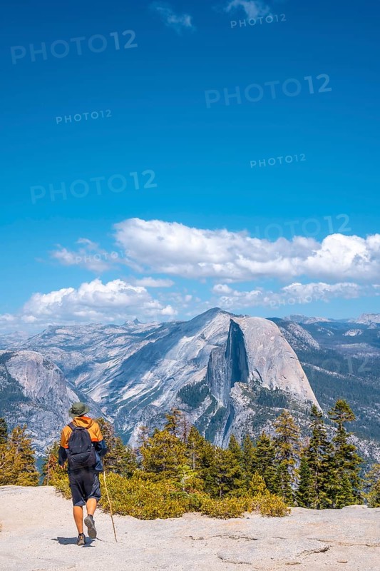 A young man walking along Sentinel Dome looking at Yosemite National Park. United States