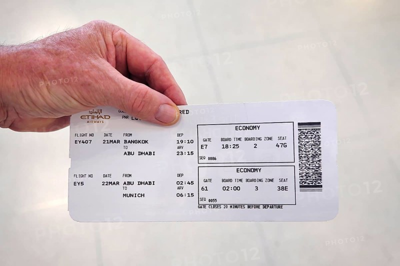 Hand holding Etihad Airways boarding pass