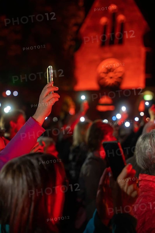 Crowd with mobile phone lights at Live Klostersommer Festival in Historic Monastery