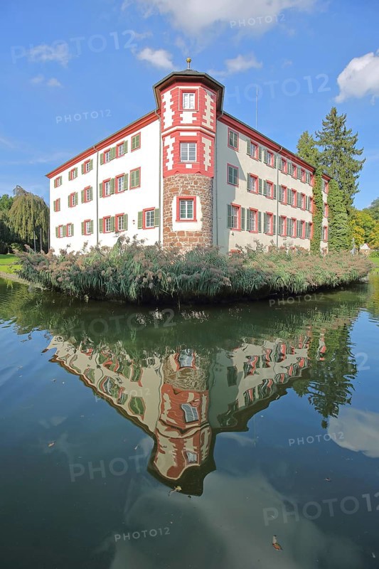 Moated castle built 16th century with reflection in the pond