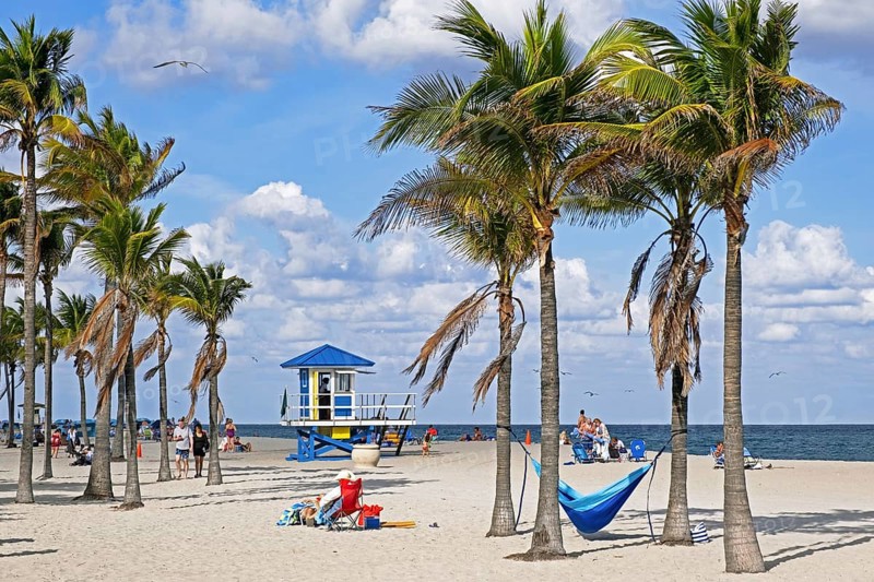 Tourists and lifeguard tower in winter on Surfside Beach along the Atlantic Ocean in Miami-Dade County