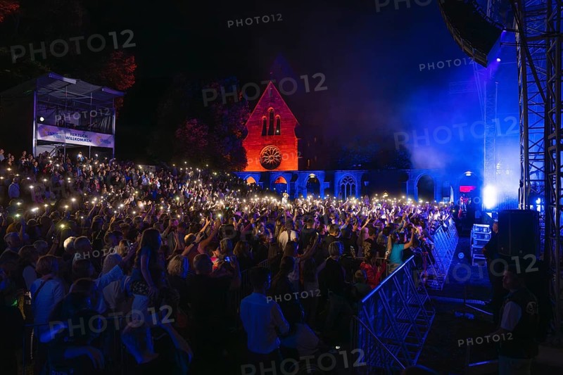 Crowd with lights at Live Klostersommer Festival in Historic Monastery