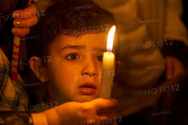 Little boy looking spellbound at a candle