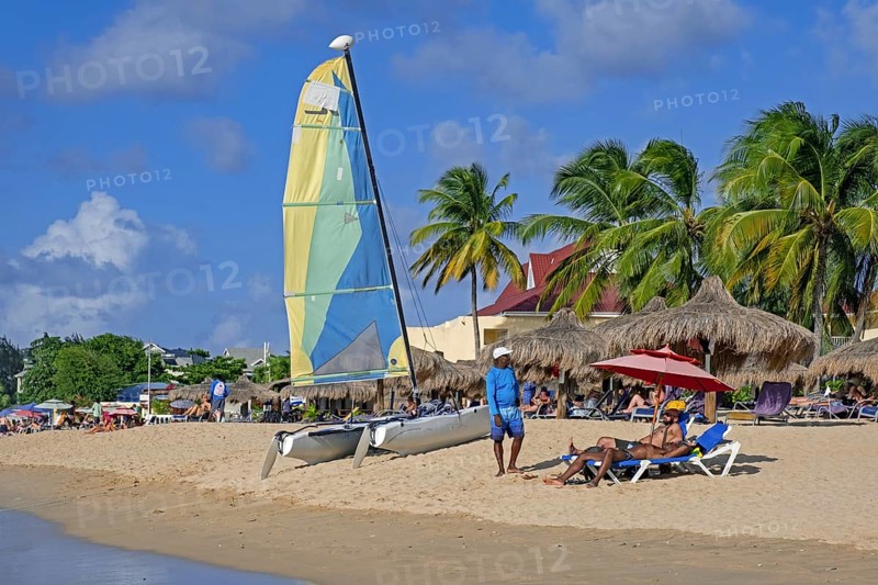 Tourists sunning on sandy beach of Rodney Bay