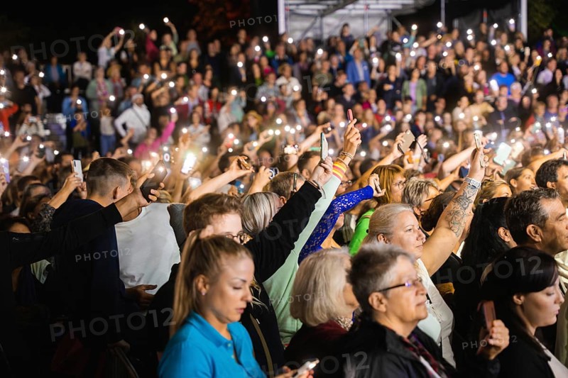 Crowd with mobile phone lights at Live Klostersommer Festival in Historic Monastery