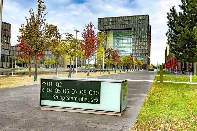 View of headquarters in the background in the form of cube of steel giant company of steel production manufacturer of steel thyssenkrupp Thyssen Krupp in the foreground signpost and reference to ancestral home of family Friedrich Krupp