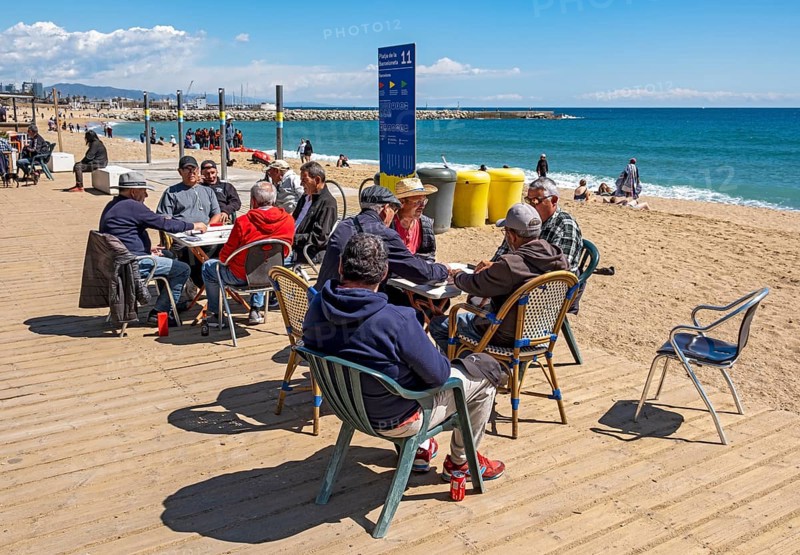 Group of men play dominoes at La Barceloneta beach