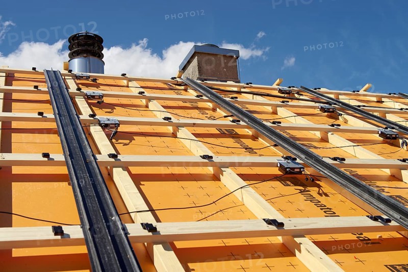 Substructure for an in-roof photovoltaic system on a roof. With foil for increased demands. Rails for rain drainage. Hooks for the solar modules