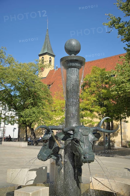Ox fountain by Gunther Stilling with sculptures bull heads and cross church