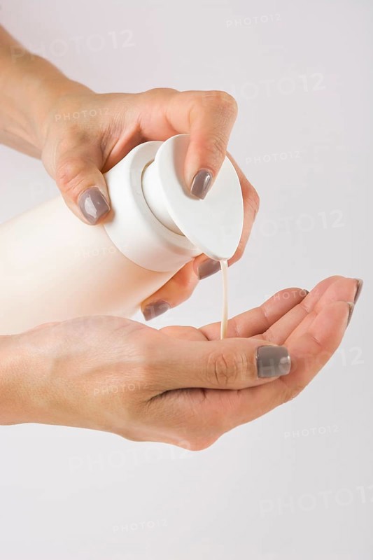 Close up female hands using hand sanitizer gel pump dispenser