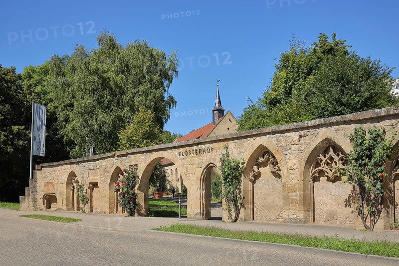 Historical stone wall with archways and monastery courtyard