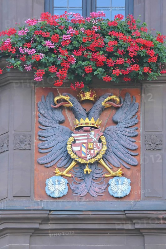 City coat of arms with double-headed eagle and floral decoration on the town hall