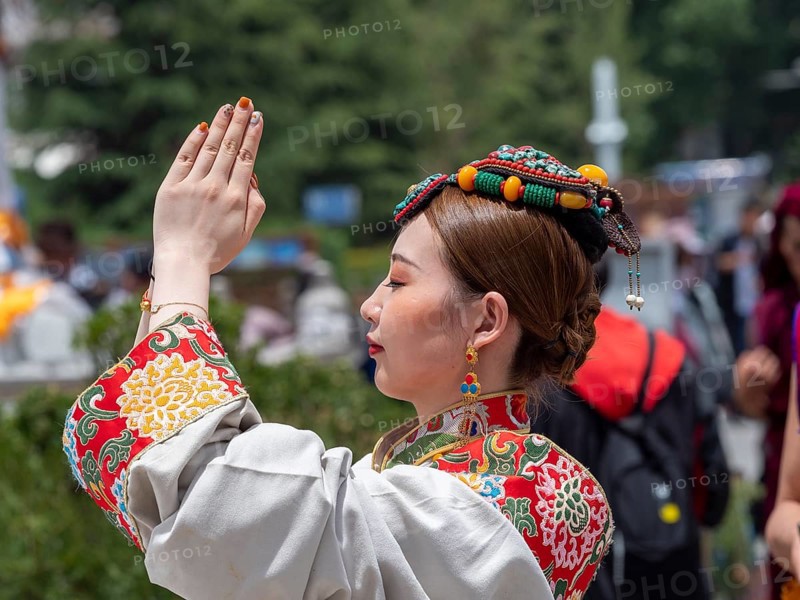 Tibetan young woman with festive hair decoration and splendid clothing
