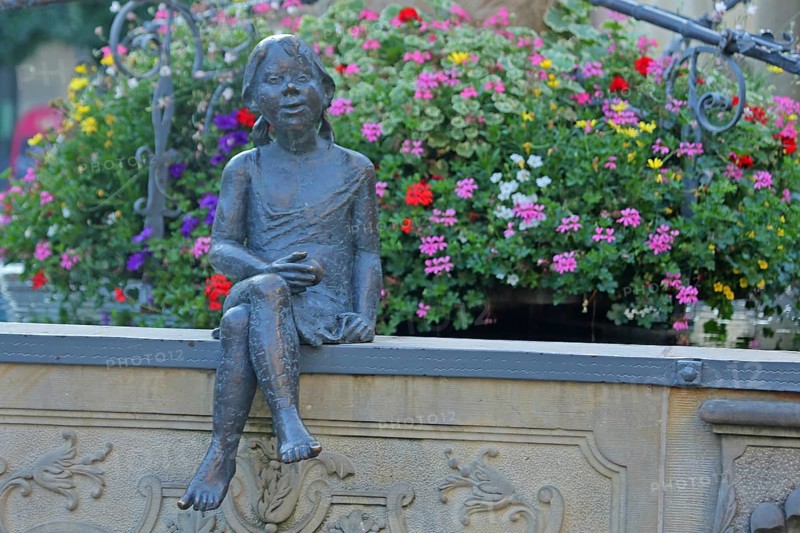 Sculpture Girl with flower decoration at the market fountain