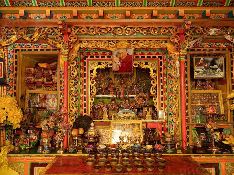 Tibetan prayer room with Dalai Llama image and wood carvings in Jiabe village