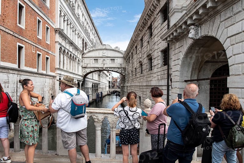 Tourists on the Ponte de Paglia visit the Bridge of Sighs