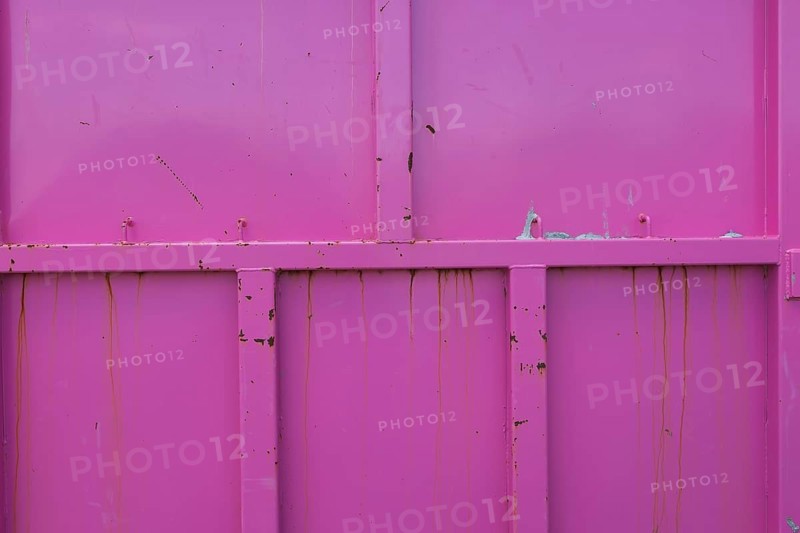 Pink painted metal container with rust stains