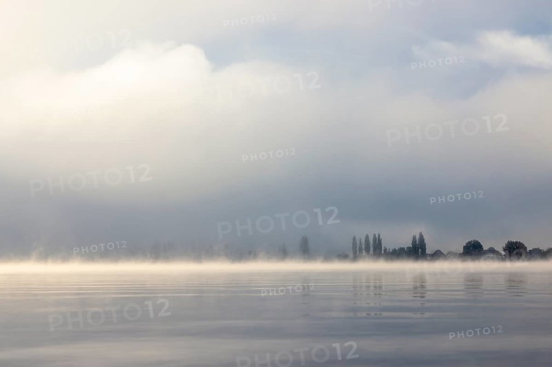 Fog over Lake Constance on an autumn morning with boats