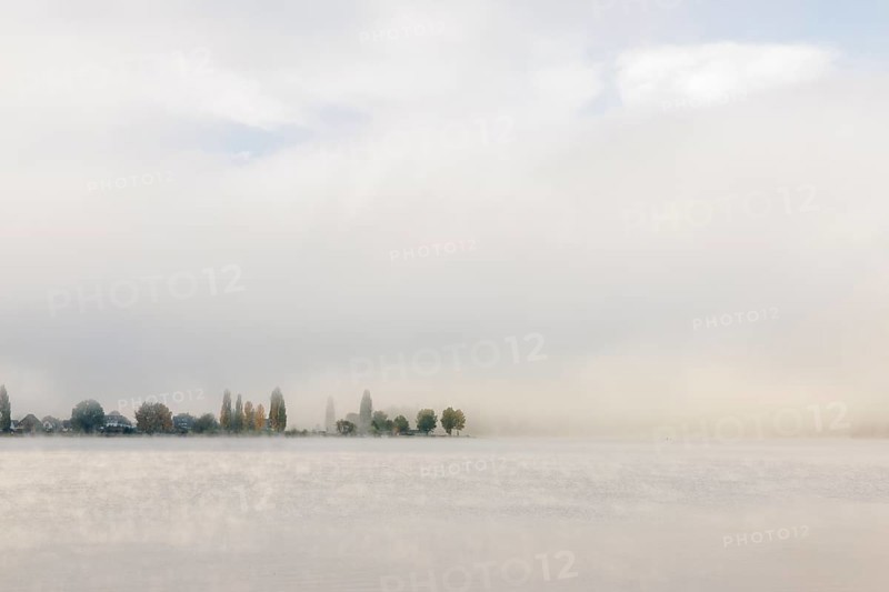 Fog over Lake Constance on an autumn morning with boats
