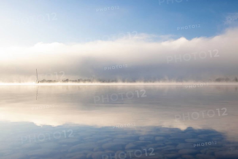 Fog over Lake Constance on an autumn morning with boats