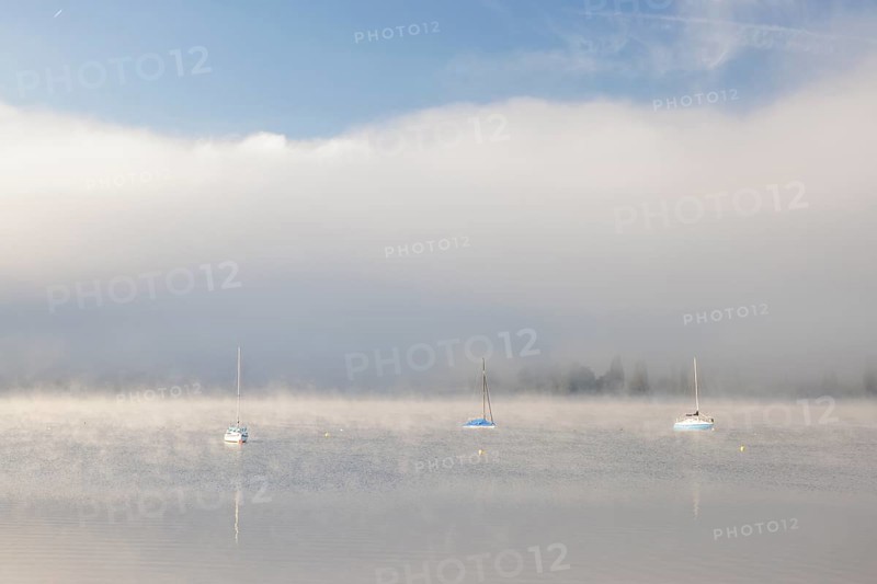 Fog over Lake Constance on an autumn morning with boats