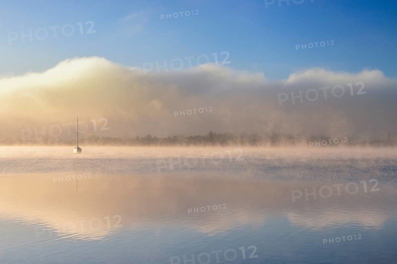 Fog over Lake Constance on an autumn morning with boats