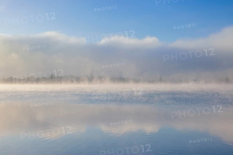 Fog over Lake Constance on an autumn morning with boats