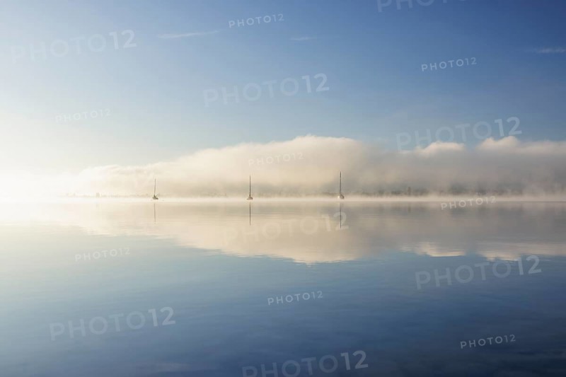 Fog over Lake Constance on an autumn morning with boats