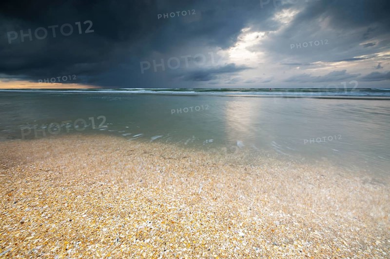 Evening mood with cloudy sky and rain on the beach and in the dunes of De Panne