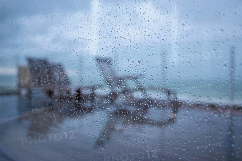 Raindrops on a window pane looking out onto the terrace
