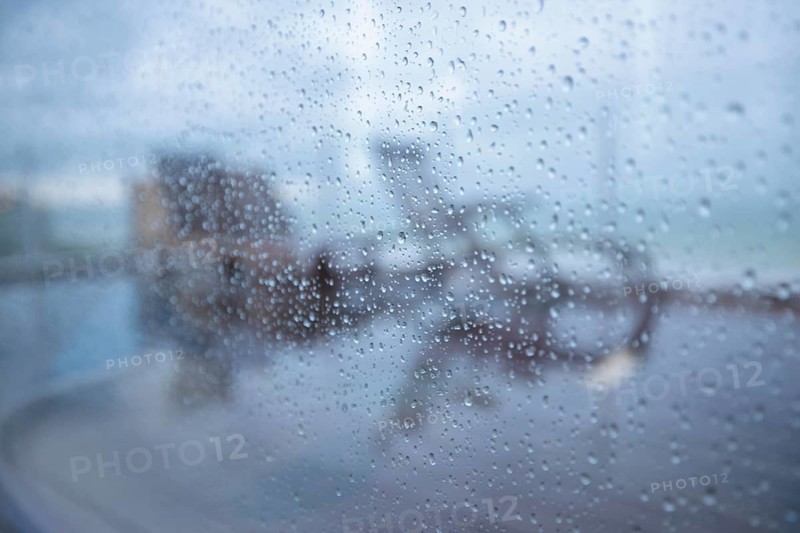 Raindrops on a window pane looking out onto the terrace