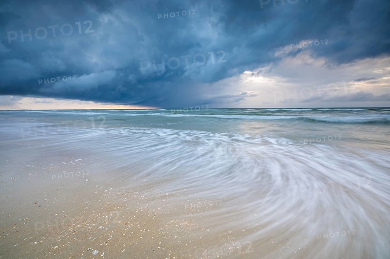 Evening mood with cloudy sky and rain on the beach and in the dunes of De Panne